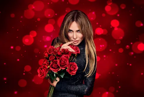 Kaya Hotels artist photo: Ziynet Sali holding red roses against a red bokeh background