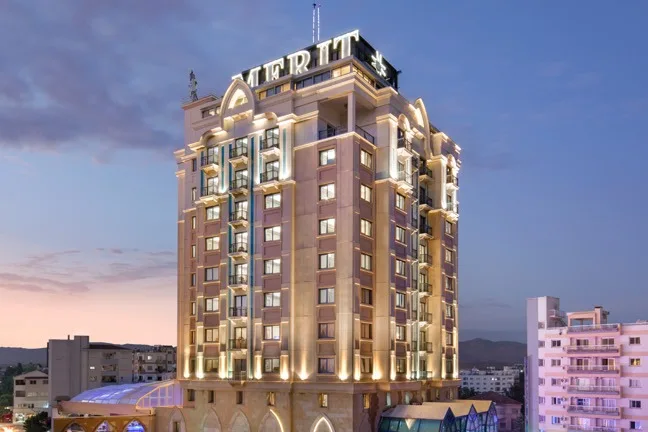 Alacakaranlıkta ışıklandırılmış Merit Lefkoşa Hotel kulesi