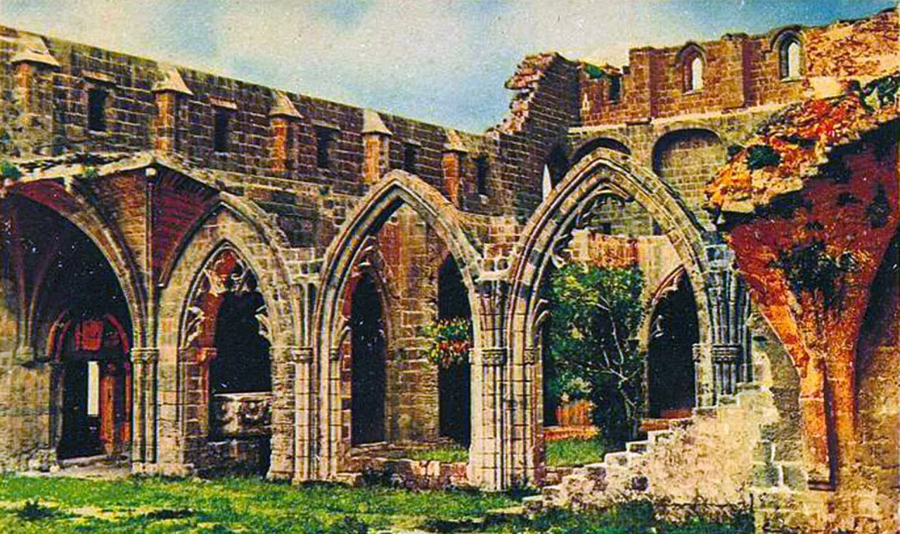 Bellapais Abbey cloister: Gothic stone arches opening onto a sunlit courtyard with trees