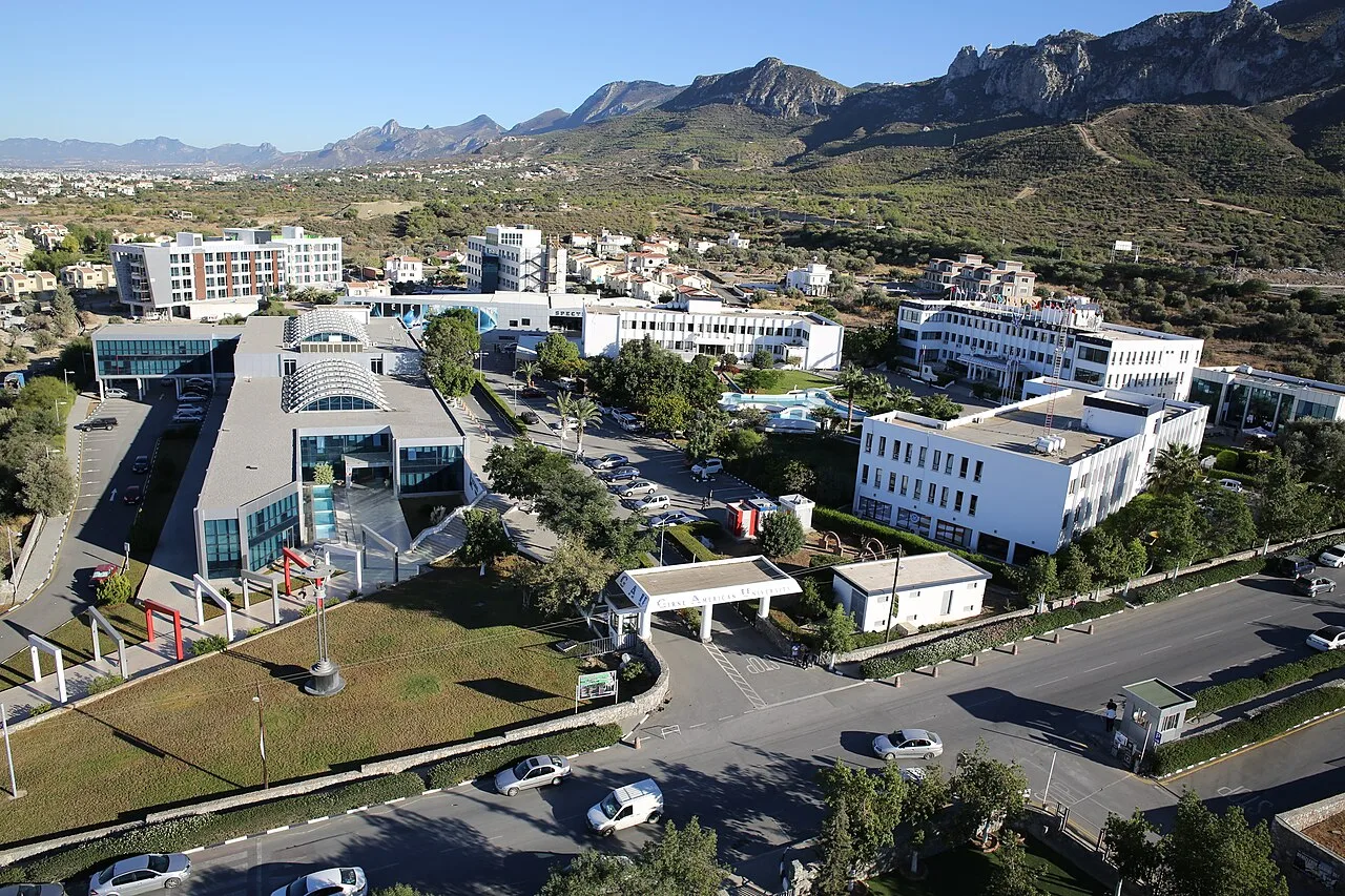 Aerial view of the Girne American University campus at Karaoğlanoğlu with the Kyrenia mountains behind