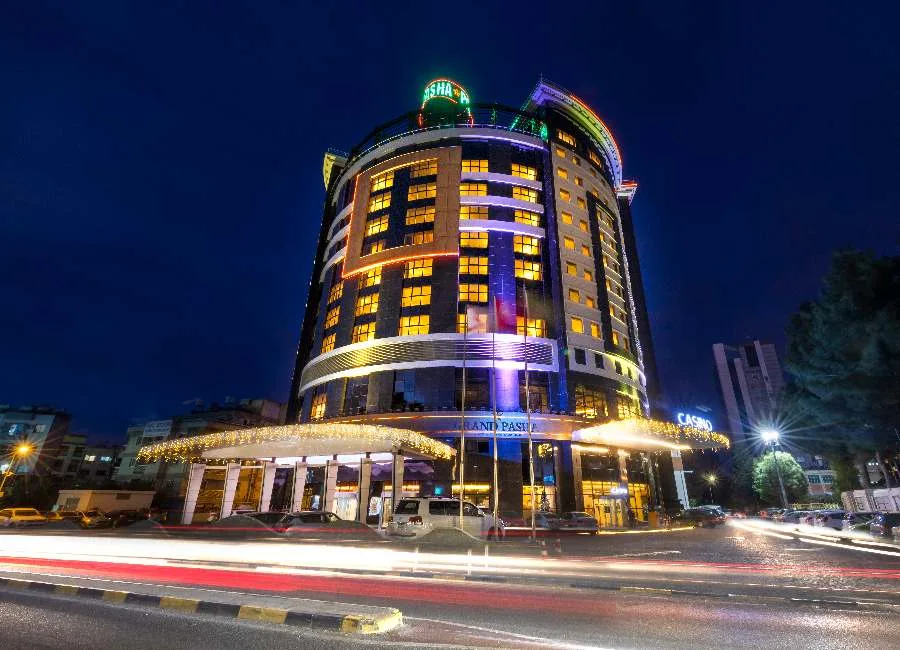 Lefkoşa Dereboyu'nda gece ışıklandırılmış Grand Pasha Nicosia otel kulesi