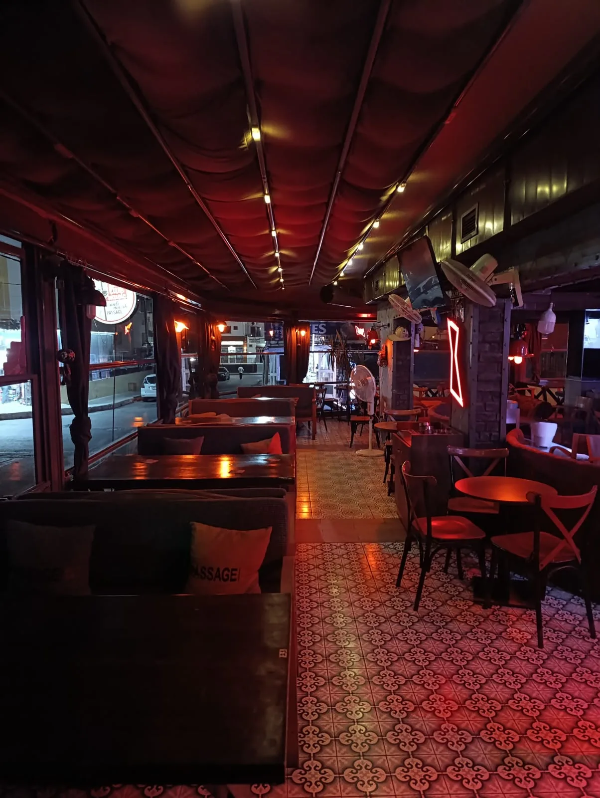 Passage N.199 interior: long bar room with red lighting, wooden tables and sofas