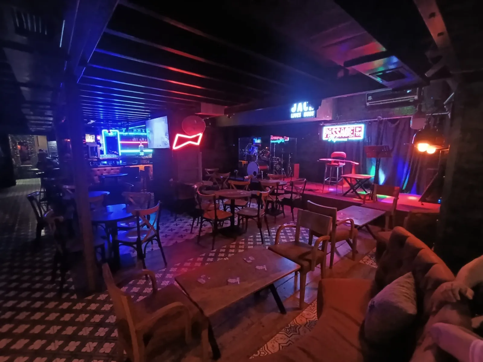 Passage N.199 interior: tables under blue and red neon signs