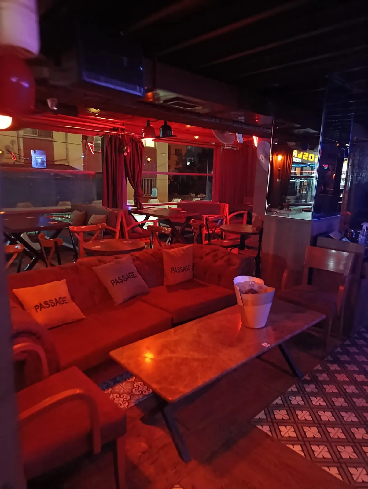 Passage N.199 interior: red sofas and low tables on patterned tiles