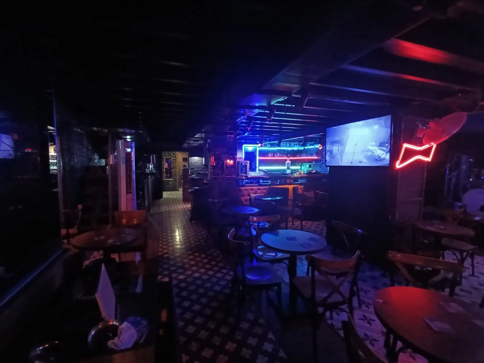 Passage N.199 interior: dim lounge with neon lights and screens