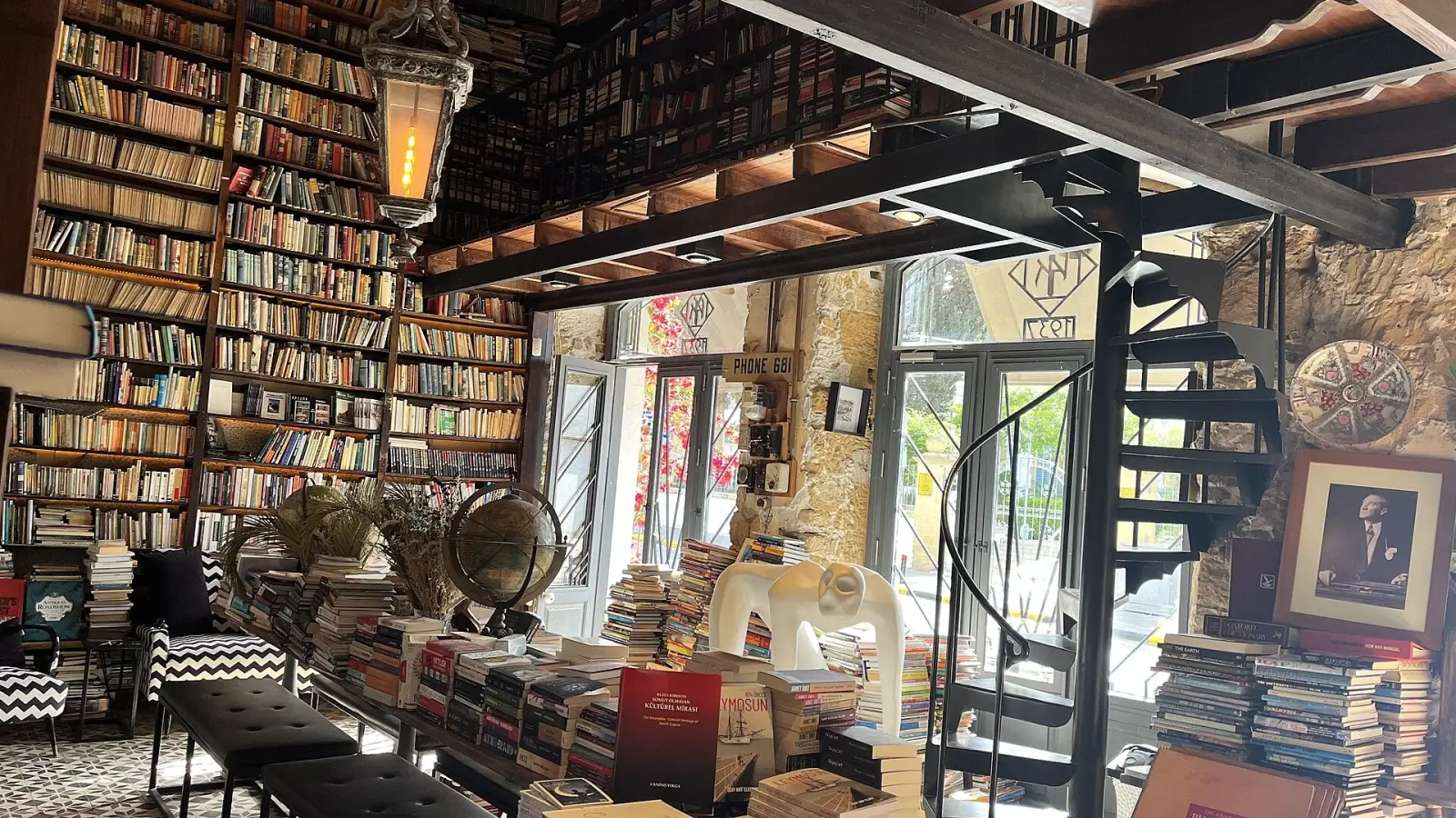 Inside Rüstem Kitabevi in Nicosia: floor-to-ceiling bookshelves, a black spiral staircase and reading tables in the historic bookshop