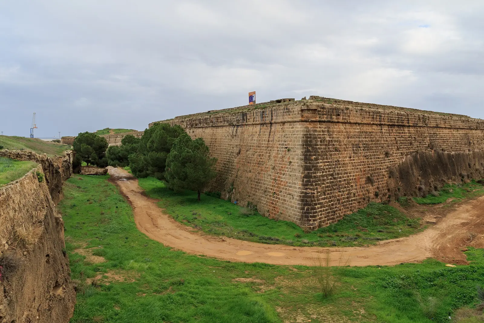 Martinengo Bastion (Çifte Mazgallar) in Famagusta: massive Venetian stone bastion walls above a grassy moat with a dirt path